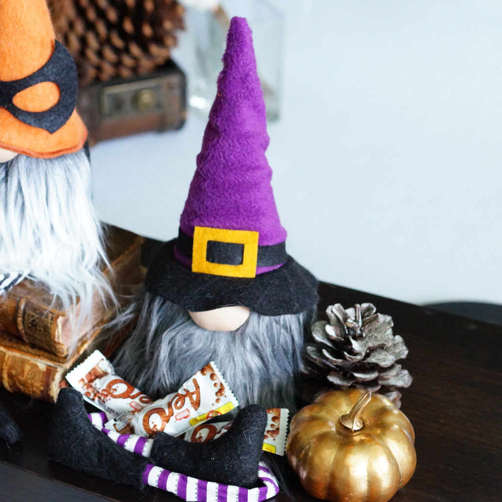 Purple Witch crossing legs with candy in the middle