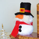 Load image into Gallery viewer, Snowman figurine with a black hat and red scarf on top of books with a white background
