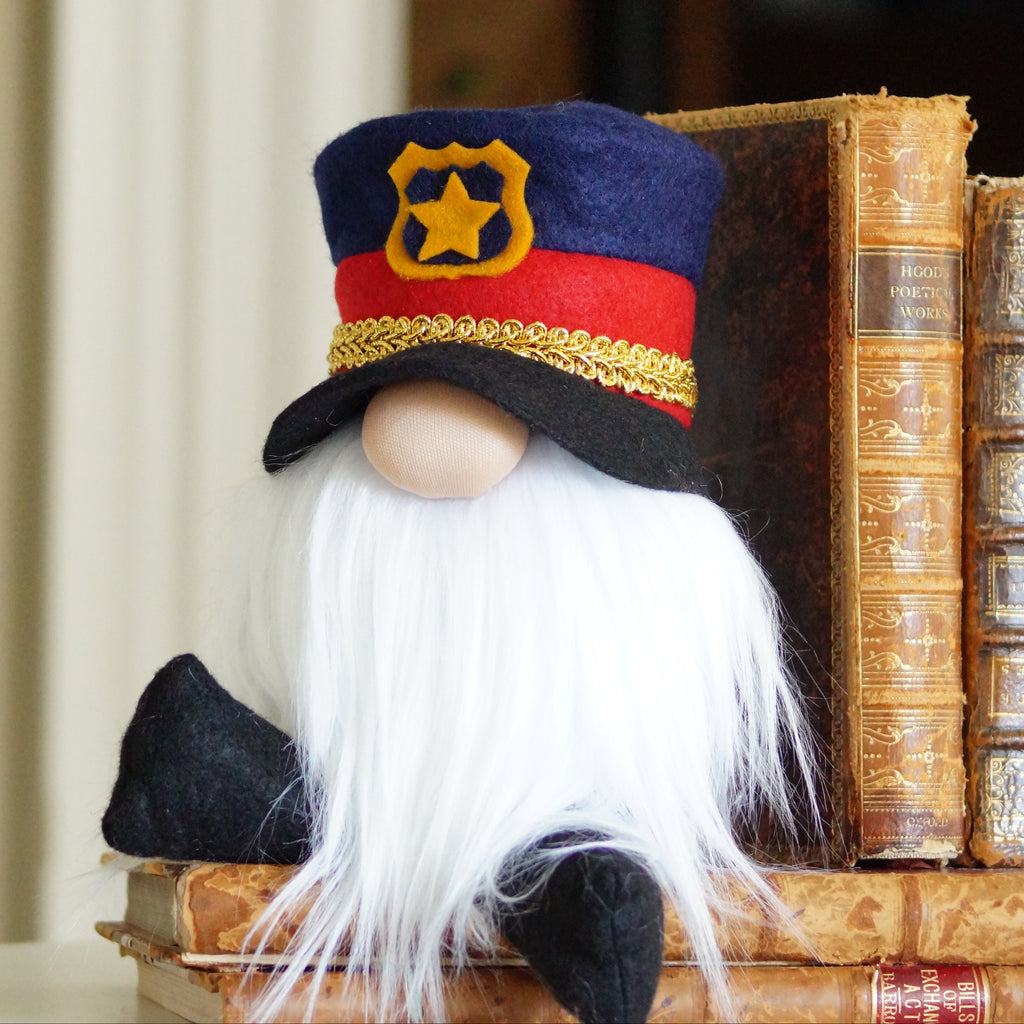 Police officer Gnome figurine with a hat on top of vintage books