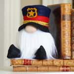 Load image into Gallery viewer, Gnome in a police uniform sitting on books with a blurred background
