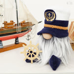 Load image into Gallery viewer, Nautical-themed gnome with a ship model and steering wheel in the background
