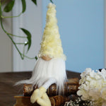 Load image into Gallery viewer, Decorative gnome with a yellow hat and white beard on a wooden surface with flowers.

