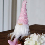 Load image into Gallery viewer, Gnome with a pink hat and white beard on a wooden surface with flowers.
