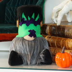 Load image into Gallery viewer, Halloween-themed gnome with green head and black shoes on a shelf with pumpkins and books.
