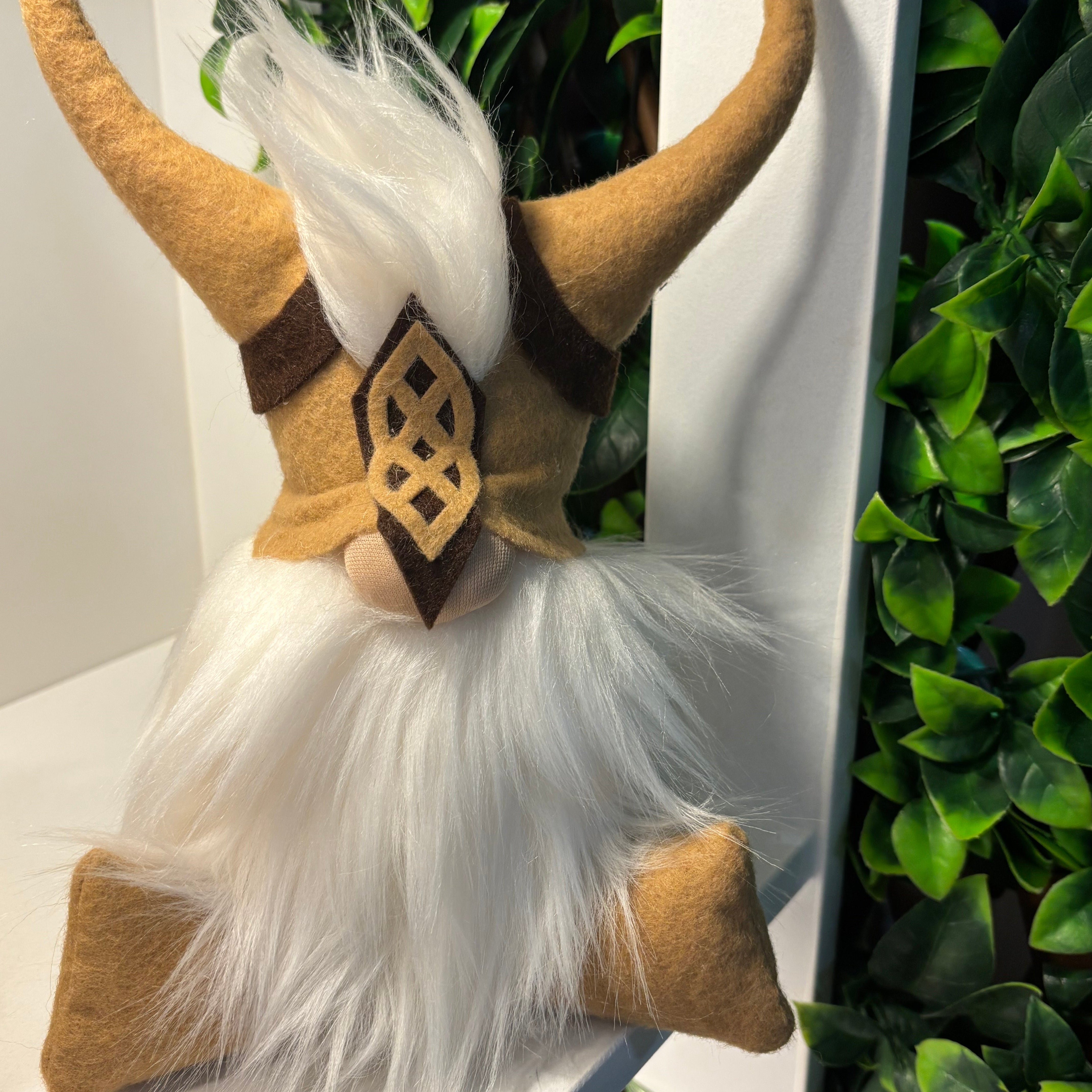 A plush gnome figure with a long white beard and felt vest acts as a handmade focus guardian, perfect for boosting productivity in your office.