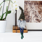 Load image into Gallery viewer, Gnome figurine with long hair sitting on a stack of books next to a potted plant and framed picture.

