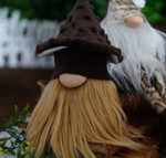 Load image into Gallery viewer, Handmade rustic gnome with a brown mushroom hat and long  beard outdoors in a natural woodland setting.
