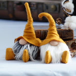 Load image into Gallery viewer, Two gnome figurines with yellow hats sit side by side, making charming home office decor or unique handmade library guardians among books and cotton.
