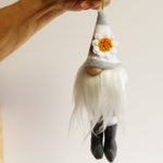 Load image into Gallery viewer, A hand holding a stripe ornament with a gnome-like character and a daisy flower on it.
