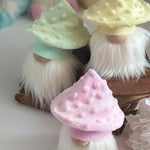 Load image into Gallery viewer, Trio of cottagecore mushroom gnomes with pink, yellow, and green textured hats displayed on a tiered surface.
