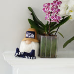Load image into Gallery viewer, Gnome figurine with tan baseball cap with best dog mom written across the cap sitting ona fireplace mantel next to an orchid
.
