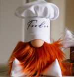 Load image into Gallery viewer, A plush gnome figure with a chef hat labeled Foodie brings gourmet magic with his orange beard and round nose, perfect for any kitchen display.
