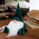 Load image into Gallery viewer, Gnome figurine with green hat and white beard on a wooden surface with books and logs in the background
