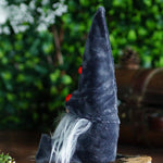 Load image into Gallery viewer, Plush gnome with a pointed hat with ladybug buttons and white beard against a blurred green background
