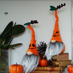 Load image into Gallery viewer, Halloween-themed gnomes with orange hats and gray beards on a shelf with pumpkins and books.
