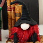 Load image into Gallery viewer, A handmade Halloween collectible fabric gnome wearing a wizard hat and red beard sitting on antique books for gothic vibe tiered tray decor
